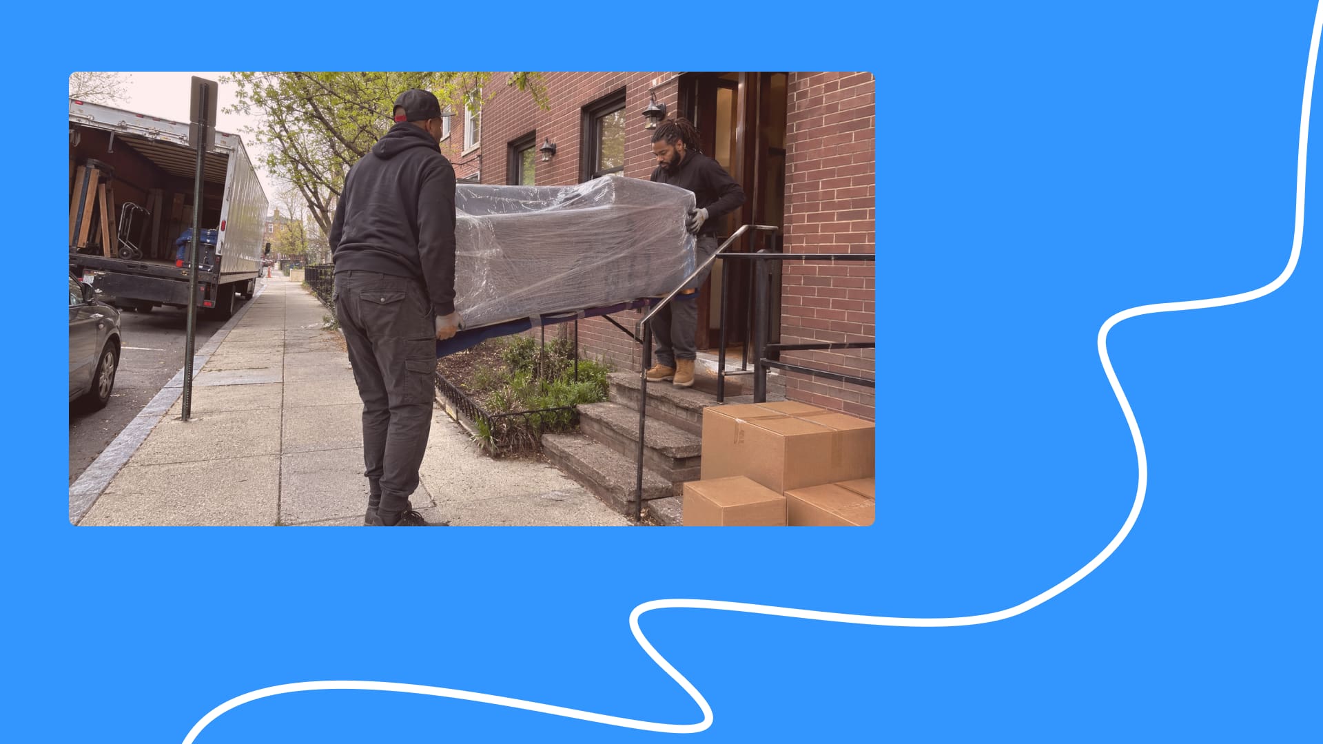 Small movers carrying wrapped furniture outside a Washington DC apartment building